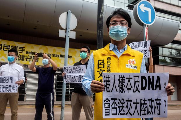 Pro-democracy district council member Lui Man-kwong holds a sign on Sunday as he protests a...