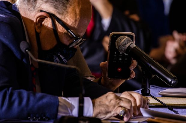 Rudy Giuliani listened as fellow Trump lawyer Jenna Ellis held a cellphone to a microphone...